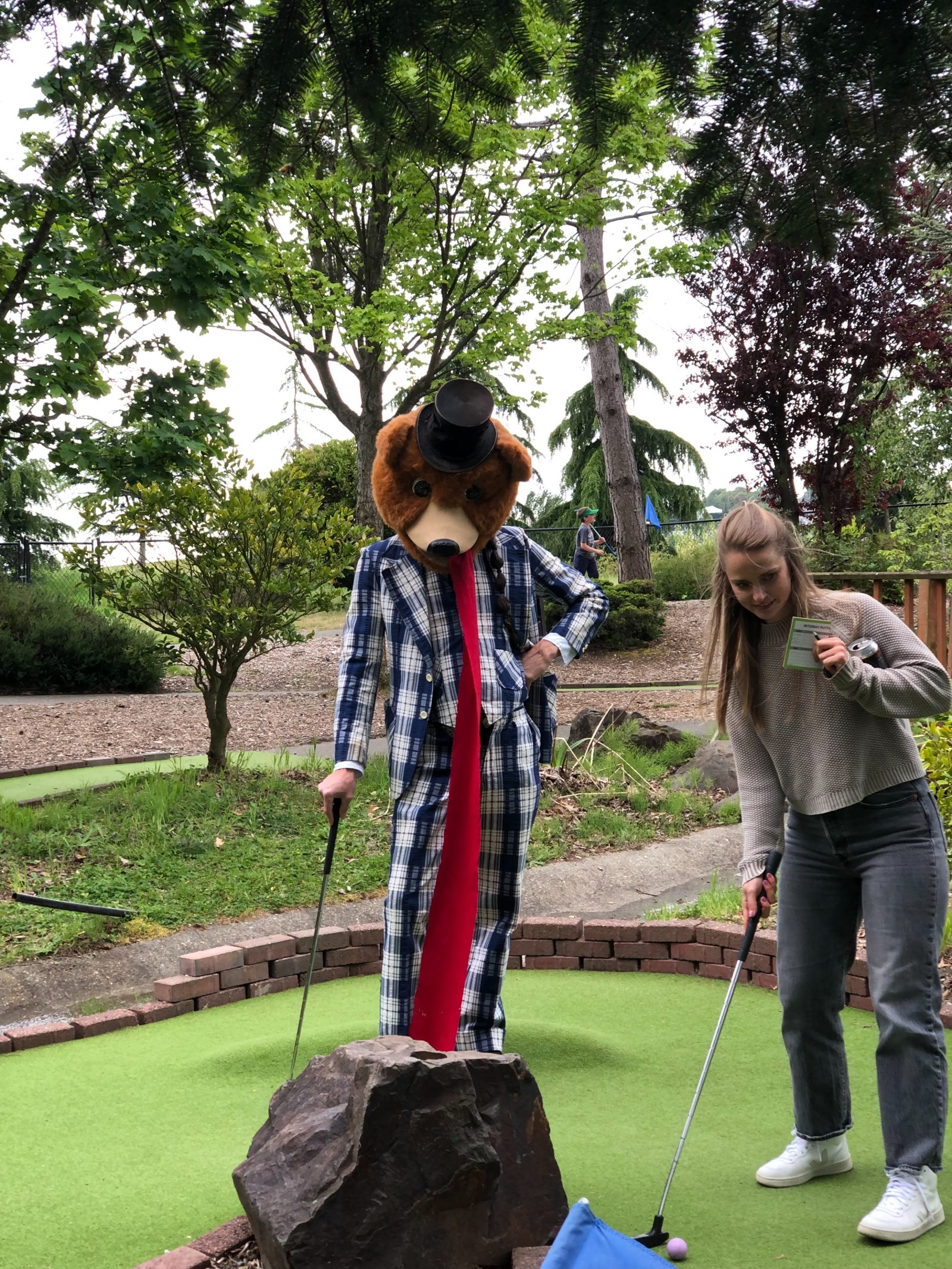 A colleague in a bear costume on the mini-golf course