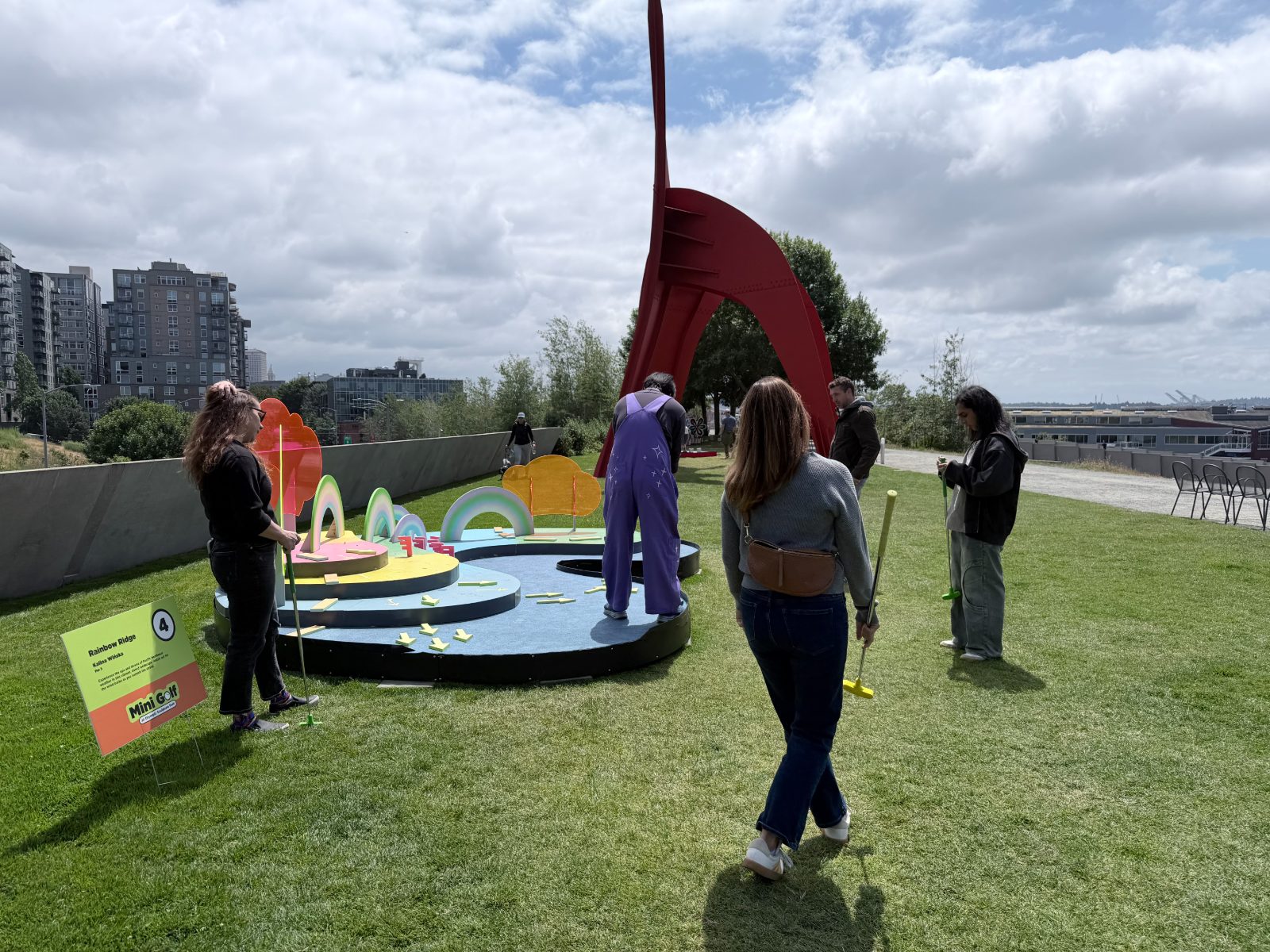 The studio playing a sculpture-park mini-golf course